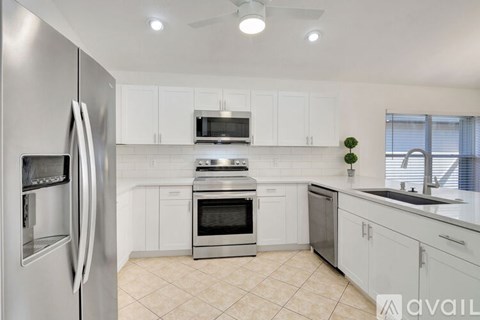 A modern kitchen with white cabinets and stainless steel appliances.
