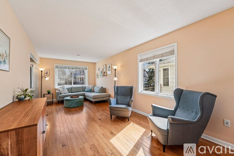 A living room with a grey sofa and a wooden floor.