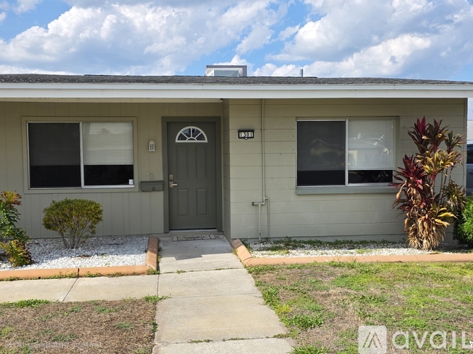 A house with a grey door and windows is for sale.