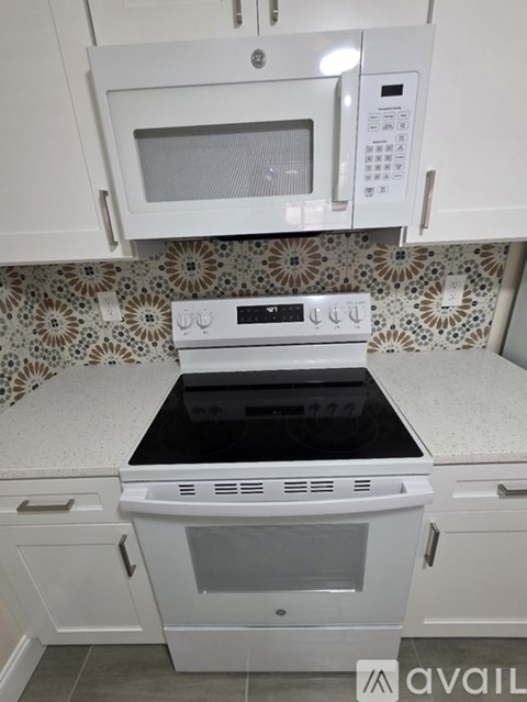 A kitchen with a white oven and microwave above it.