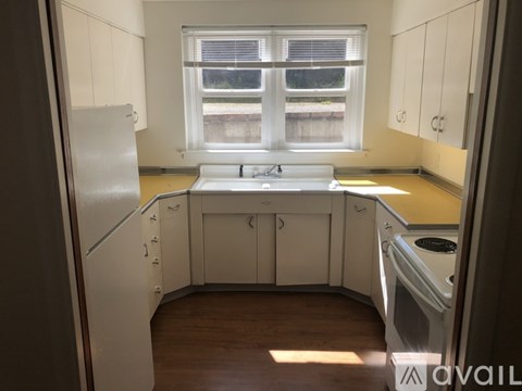 A kitchen with white cabinets and a window.