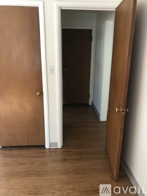 A wooden door is open to a hallway.