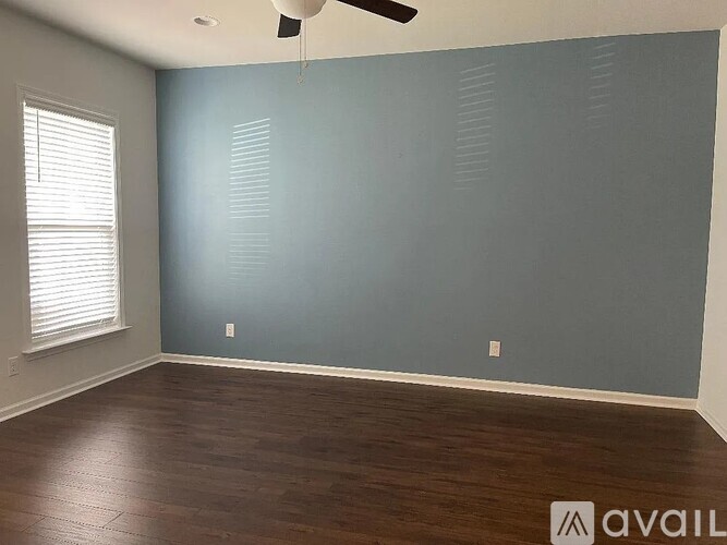 A room with a ceiling fan and a window with blinds.