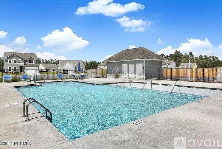 A swimming pool surrounded by a fence and a small building in the background.