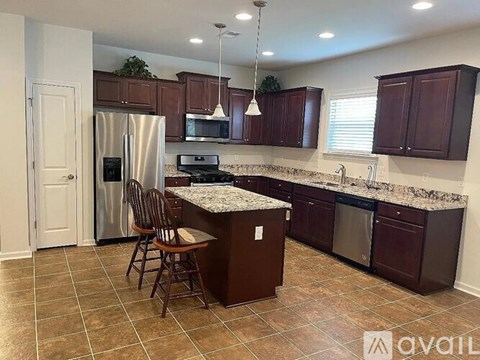 A kitchen with brown cabinets and a granite countertop.