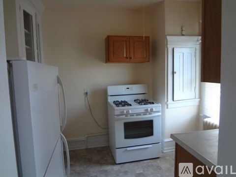 A kitchen with a white fridge, stove and wooden cabinets.