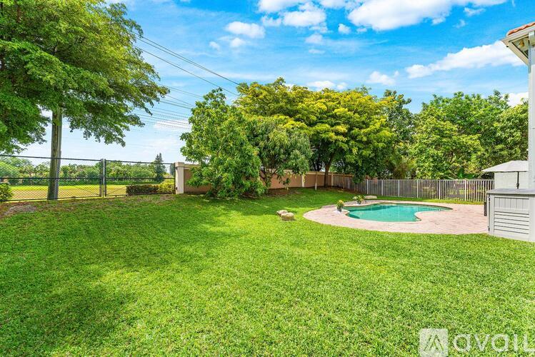 A backyard with a pool and a fence.