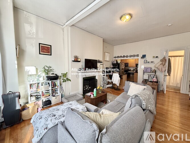 A living room with a grey couch and a fireplace.