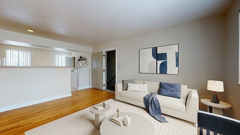 A living room with a white couch and a blue throw.