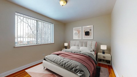 A bedroom with a bed, nightstands, and a window with blinds.