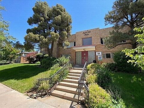 A building with a red door and a sign that says "Pine Hill Apartments".