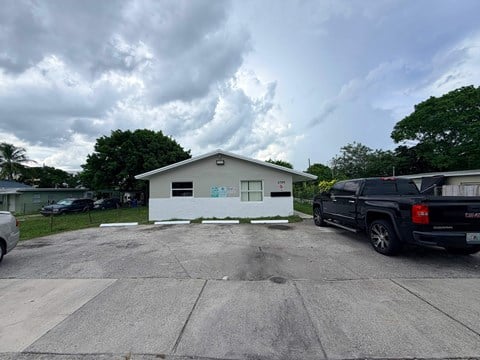 A white building with a parking lot in front of it.