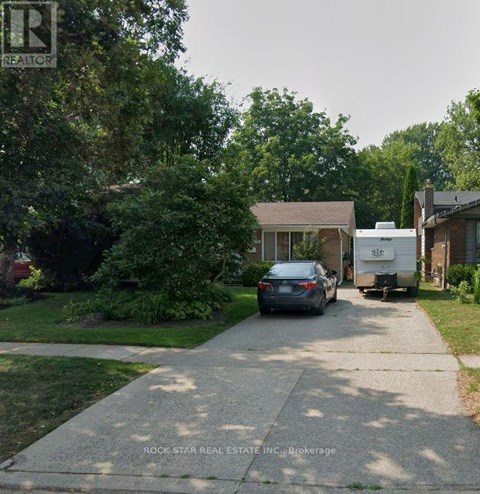 A car is parked on a driveway in front of a house.