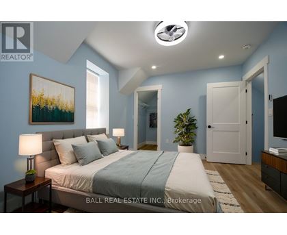 A bedroom with a bed, nightstands, and a painting on the wall.