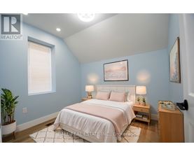 A bedroom with a bed, nightstand, and lamp.