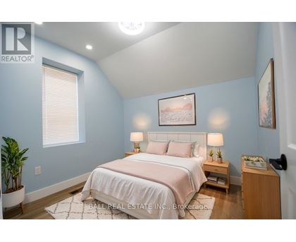 A bedroom with a bed, nightstand, and lamp.