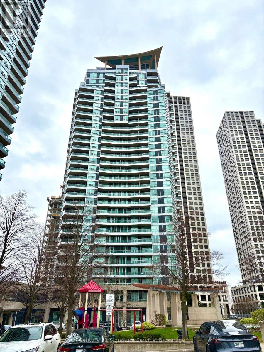 A tall building with a red roof and a playground in front of it.