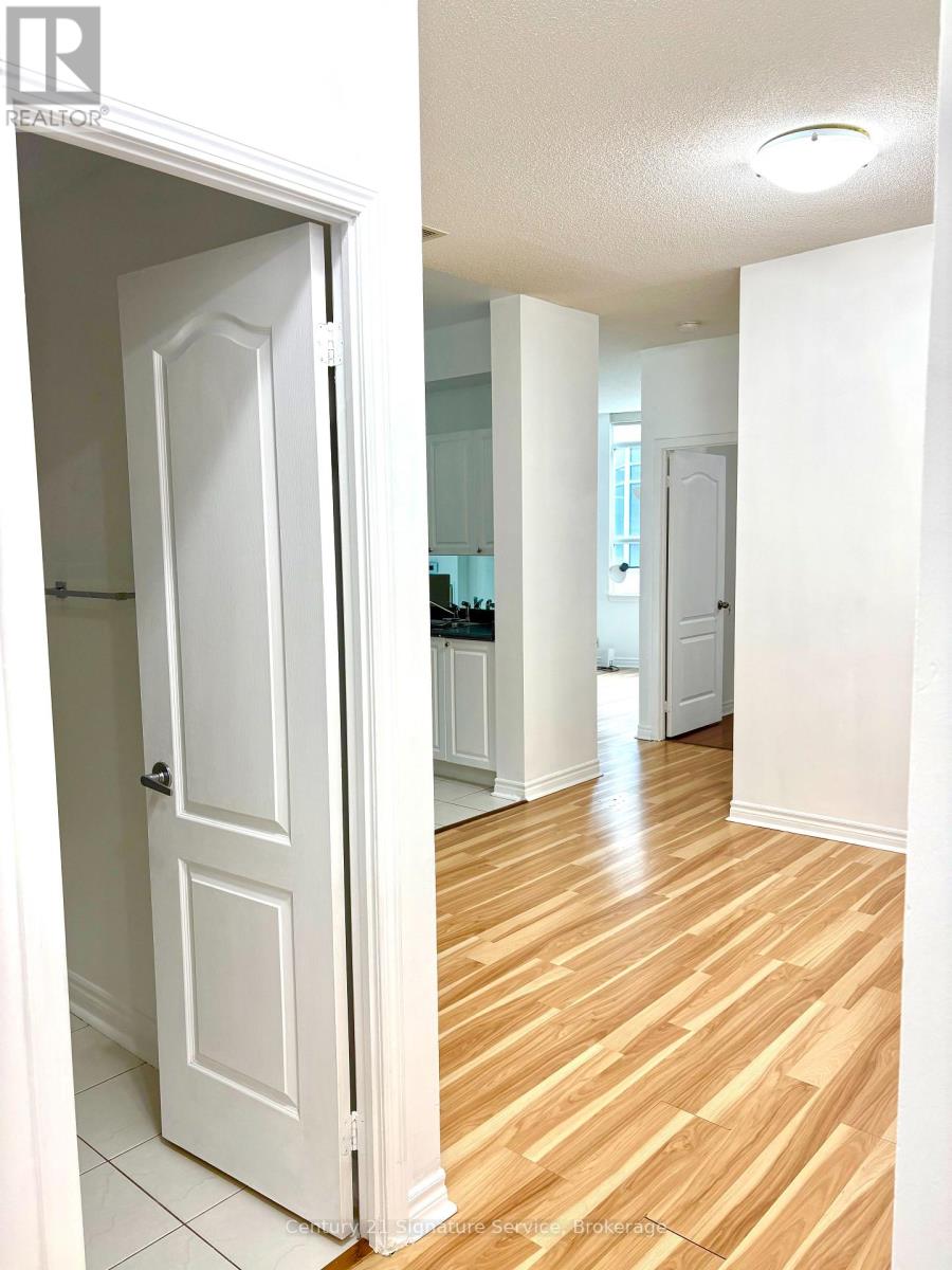 A white door is open to a hallway with wood floors.