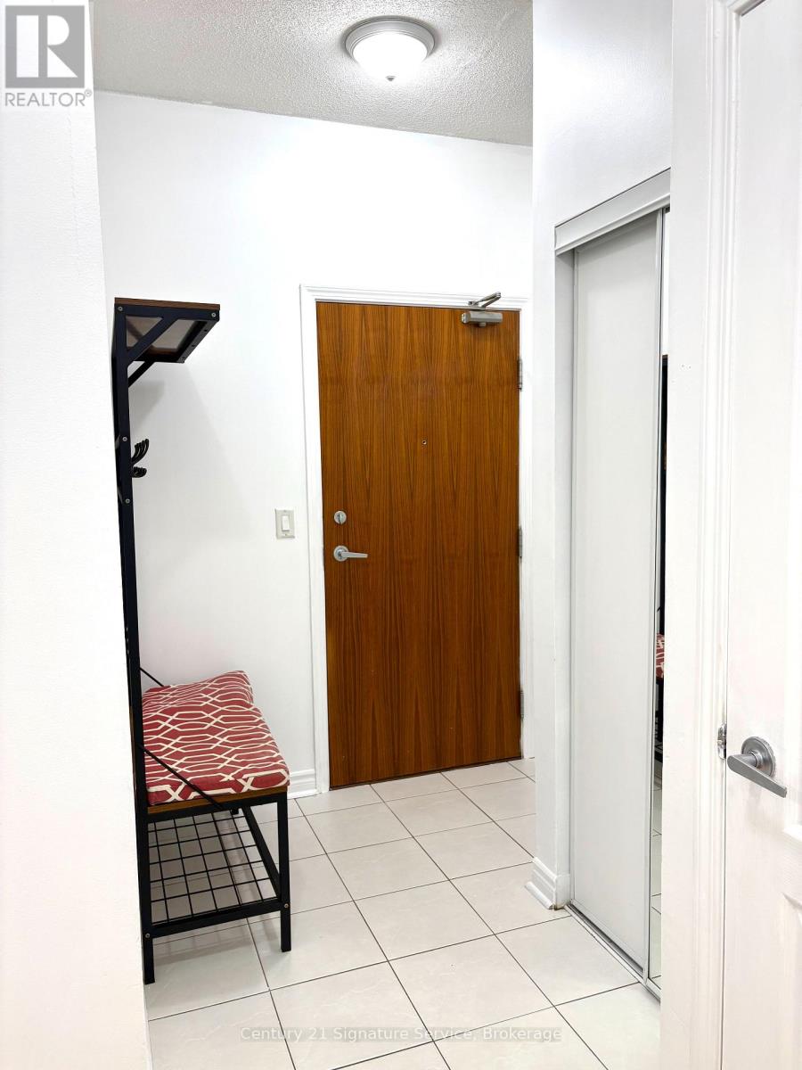 A hallway with a wooden door and a bench with a red and white striped cushion.
