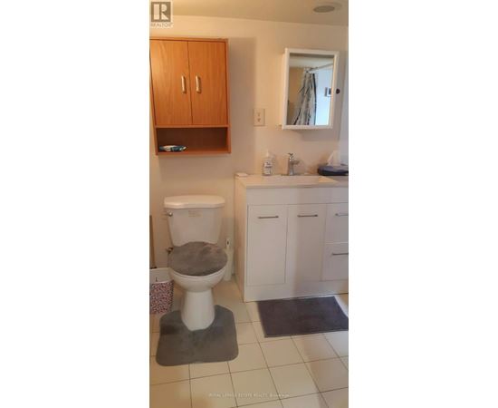A bathroom with a toilet, sink, and medicine cabinet.