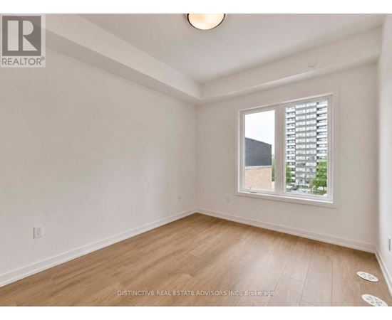 A room with a window showing a view of a building outside.