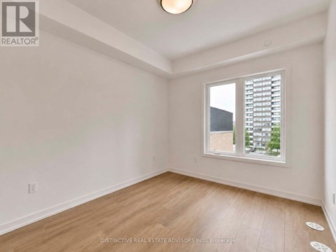 A room with a window showing a view of a building outside.