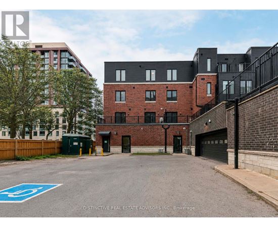 A parking lot with a blue handicap sign in front of a brick building.