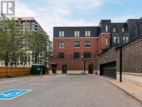 A parking lot with a blue handicap sign in front of a brick building.