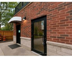 A brick building with a black door and a white awning.