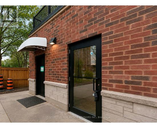 A brick building with a black door and a white awning.