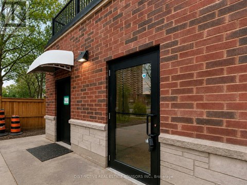 A brick building with a black door and a white awning.