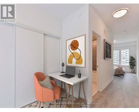 A room with a desk, chair, and painting.