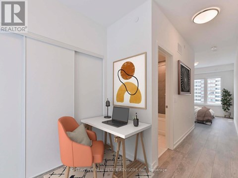 A room with a desk, chair, and painting.