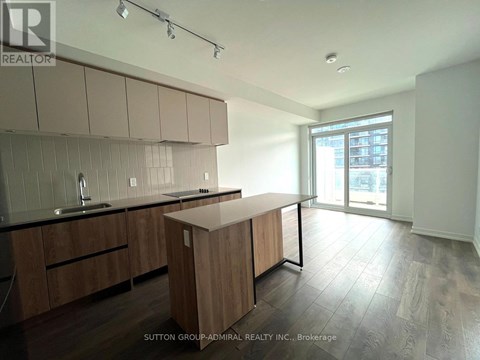 A kitchen with wooden cabinets and a black countertop.