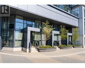 A modern building with glass windows and a sign that reads "RE/MAX HALLMARK REALTY LTD. Brokerage".