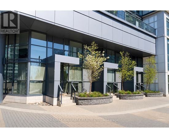 A modern building with glass windows and a sign that reads "RE/MAX HALLMARK REALTY LTD. Brokerage".