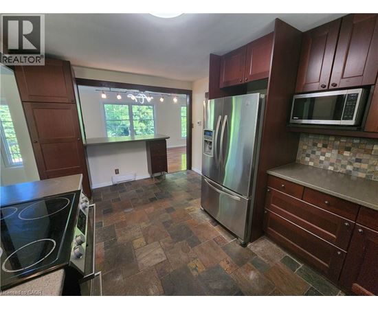 A kitchen with a stove top oven and a refrigerator.