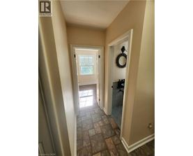 A hallway with a door on the right and a window on the other side.