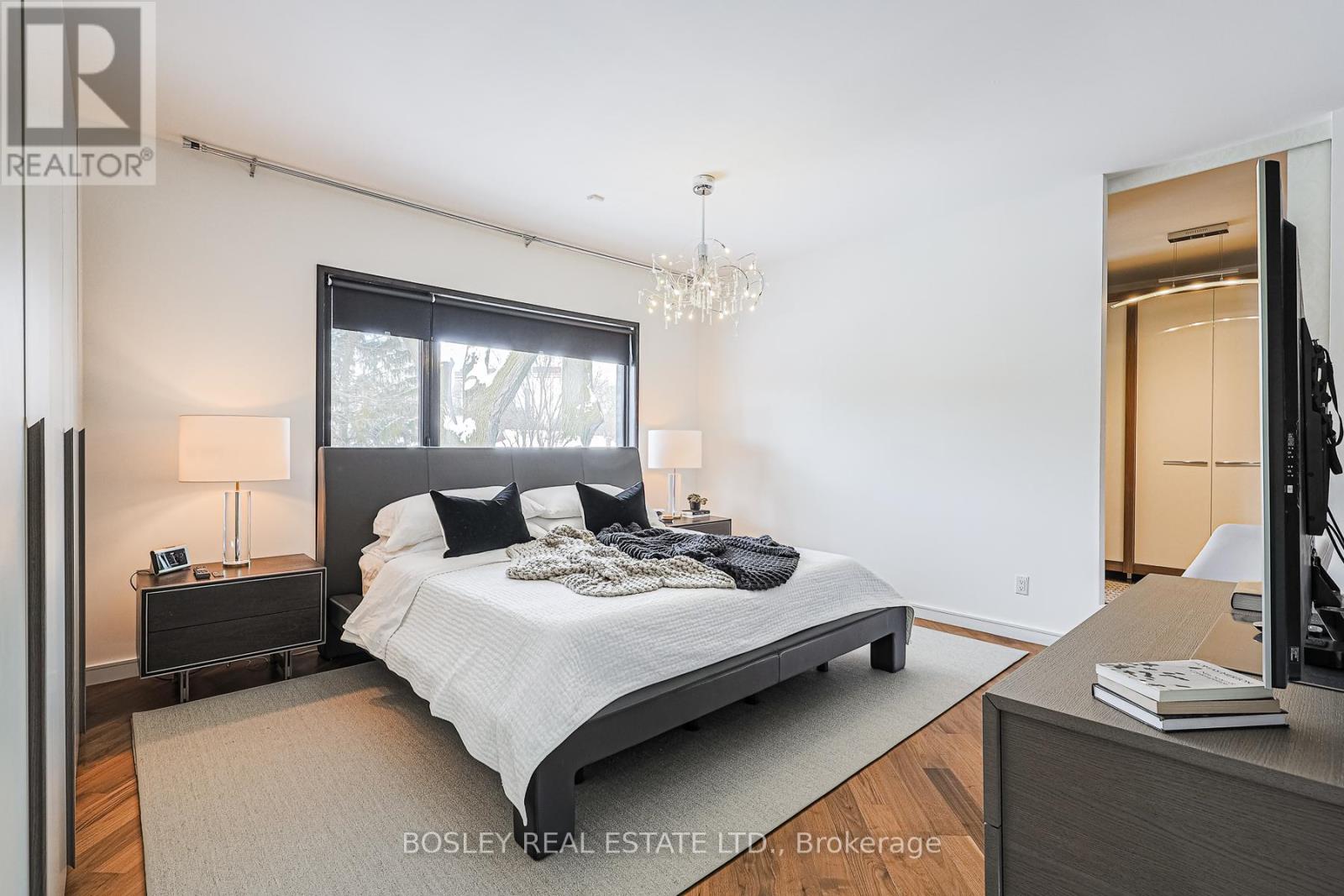 A bedroom with a large bed and a chandelier.