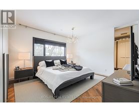 A bedroom with a large bed and a chandelier.