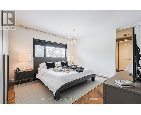 A bedroom with a large bed and a chandelier.
