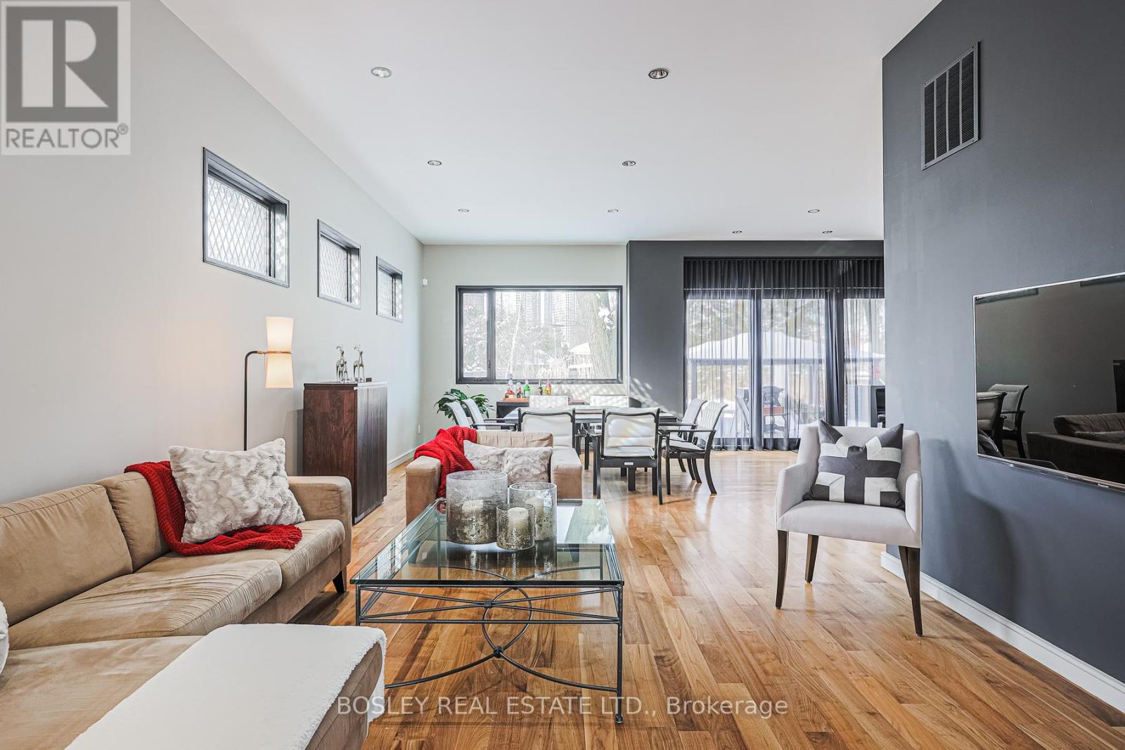 A modern living room with a glass coffee table and a large window.