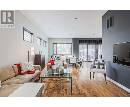 A modern living room with a glass coffee table and a large window.