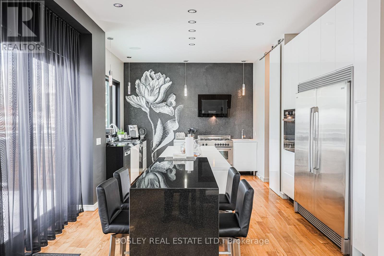 A modern kitchen with a black table and chairs.