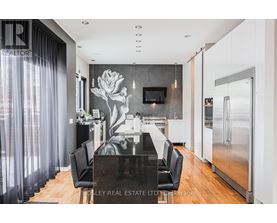A modern kitchen with a black table and chairs.