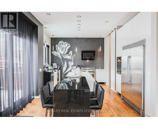 A modern kitchen with a black table and chairs.