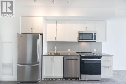 A modern kitchen with white cabinets and stainless steel appliances.