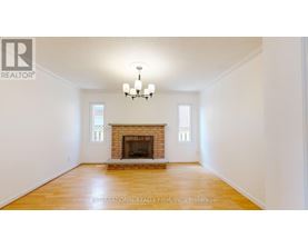 A large, empty room with a fireplace and a chandelier.