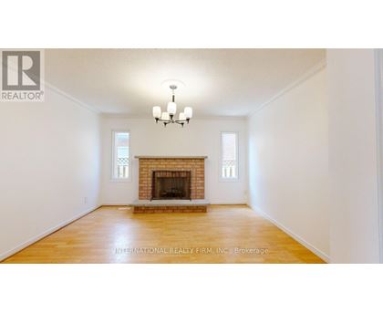 A large, empty room with a fireplace and a chandelier.