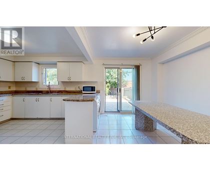 A kitchen with white cabinets and a granite countertop.
